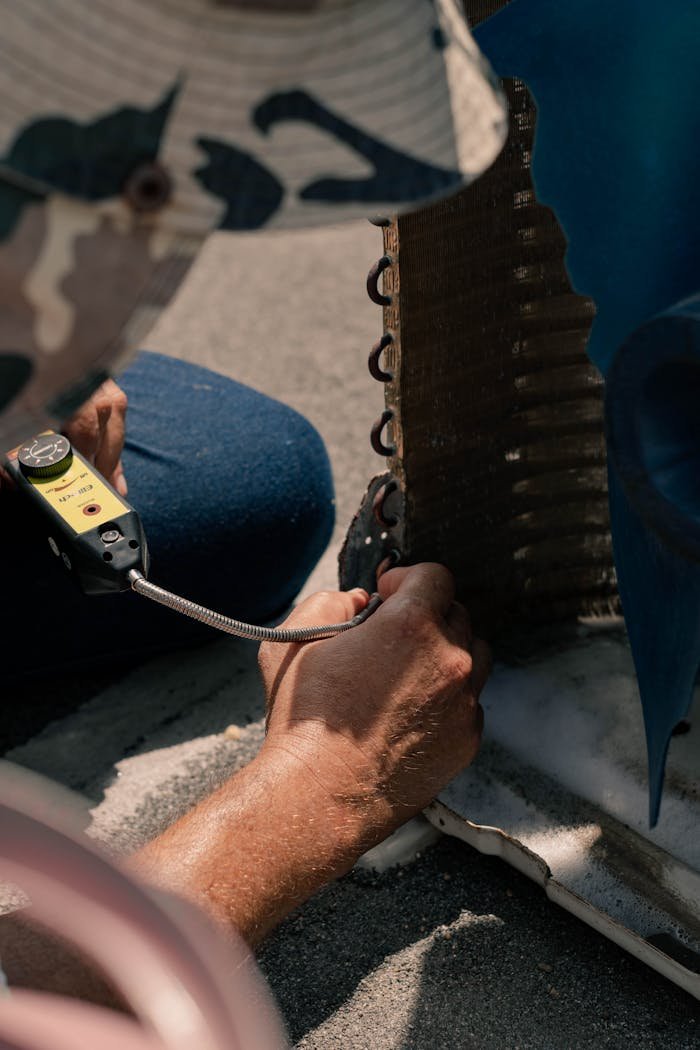 our-stories Technician repairing an air conditioner unit with tools, showcasing detailed maintenance process.